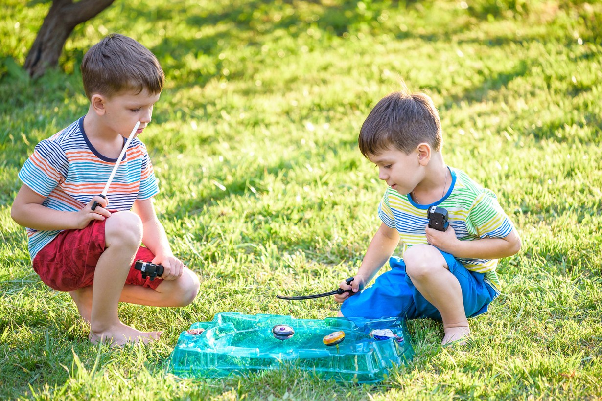 two kids playing Beyblade