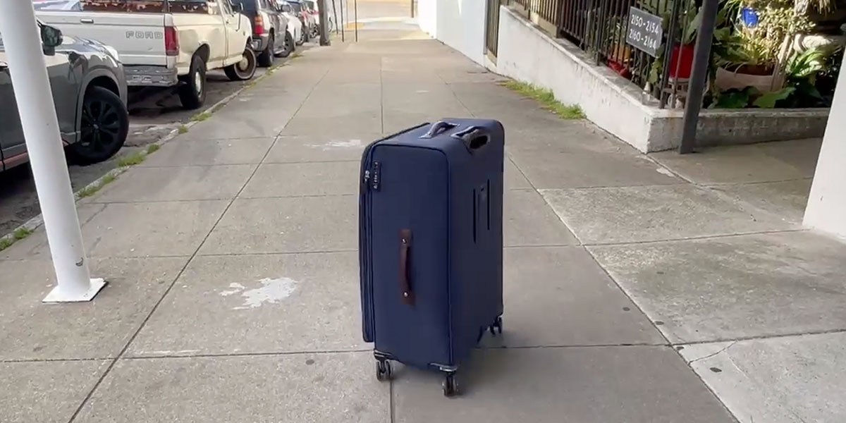 Travelpro Platinum Elite Softside Expandable Checked Luggage on sidewalk Travelpro Platinum Elite Softside Expandable Checked Luggage on sidewalk