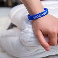 a hand on top of a white comforter