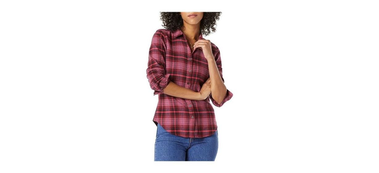 A woman wearing a long-sleeve red plaid shirt with the sleeves rolled up to the elbows