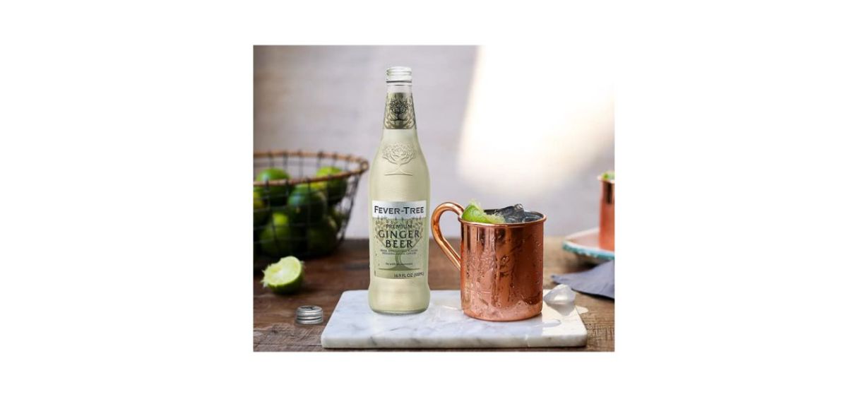 Fever-Tree ginger beer bottle next to a copper mug and some limes