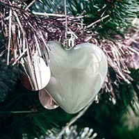 Heart-shaped ornament and pink garland on Christmas tree